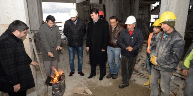 Dündar okul inşaatında işçilerle tenekede ateş yakıp ısındı