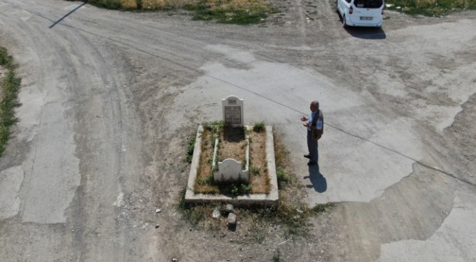 Yol ortasında kalan mezar görenleri şaşırtıyor