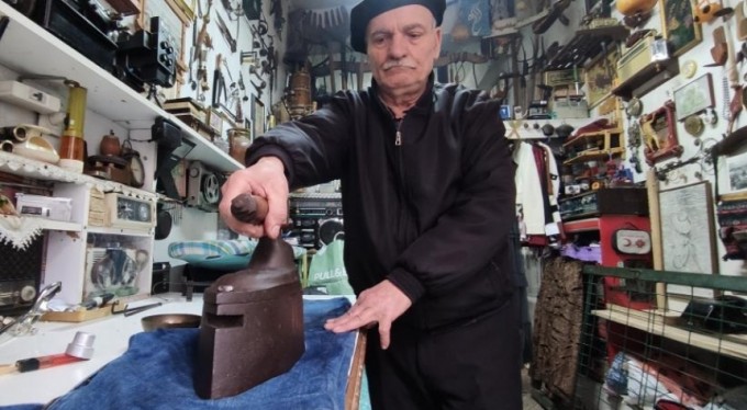 Terzi kömürlü ütüyle kumaşları ütülüyor