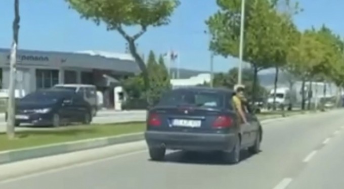 Canını hiçe sayan çocuk, otomobilin camından sarktı