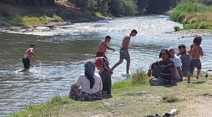 Bursa'da mahalle muhtarı sıcaktan bunalan köy sakinlerine plaj yaptırdı