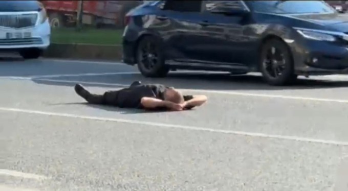 Bursa'da bir adam yüzlerce aracın geçtiği karayoluna boylu boyunca uzandı