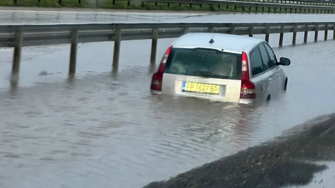 Bursa'da sağanakta göle dönen yolda araç mahsur kaldı