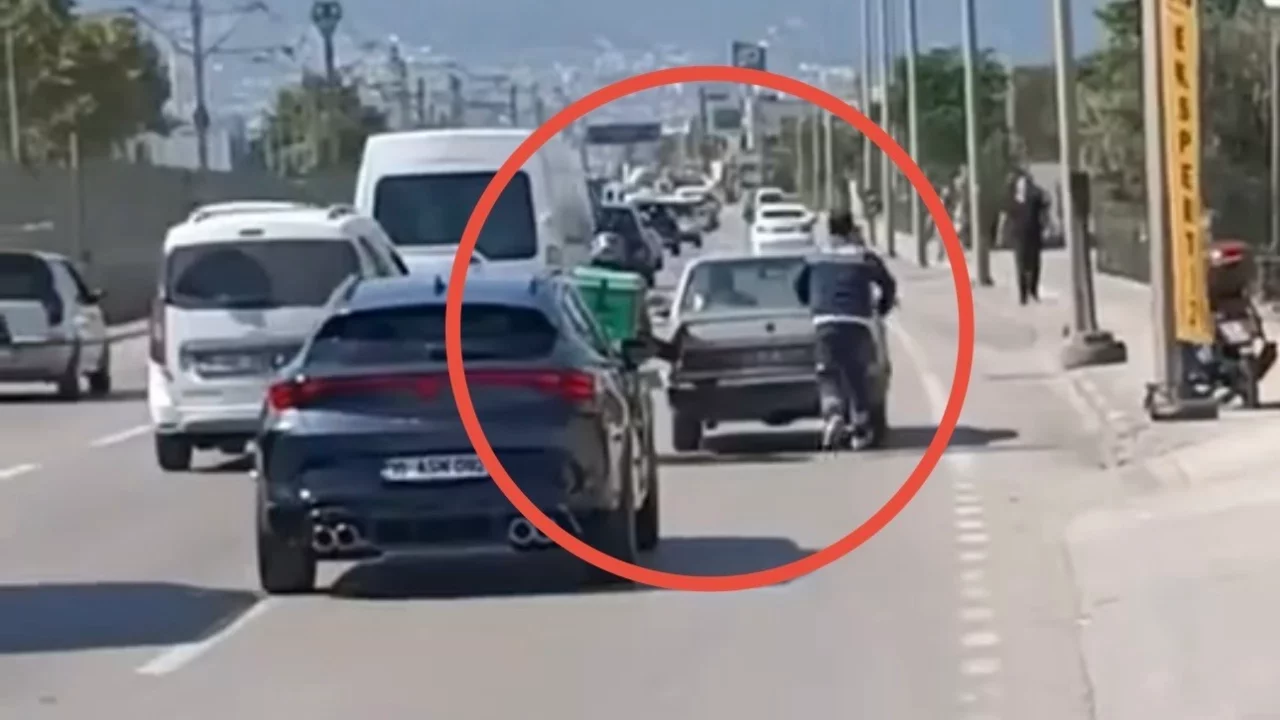 Bursa'da arızalanan otomobili motokurye ayağıyla itti